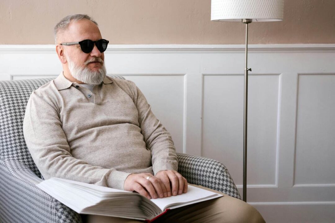 Homem sentado fazendo leitura em Braille